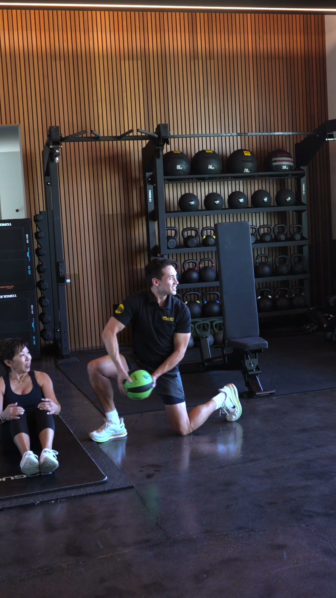 Trainer coaching a client in a well-equipped home gym